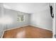 Bedroom with hardwood floors and a wall-mounted TV at 8416 Buckingham Dr, Columbus, IN 47201