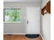 Bright entryway featuring hardwood floors, a window, and a coat rack, creating a welcoming space at 8416 Buckingham Dr, Columbus, IN 47201