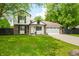 Charming two-story home with a brick and siding exterior, lush green lawn, and attached two car garage at 8416 Buckingham Dr, Columbus, IN 47201