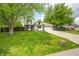 Two-story home features a well-manicured lawn, mature trees, a driveway, and an attached garage at 8416 Buckingham Dr, Columbus, IN 47201