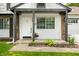 Charming front porch with white siding, brick accents, and a beautifully landscaped entryway at 8416 Buckingham Dr, Columbus, IN 47201