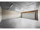 Spacious garage with white door, gray flooring and walls, and overhead lighting at 8416 Buckingham Dr, Columbus, IN 47201