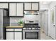 Kitchen with stainless steel oven and hood, updated cabinets, granite countertops, and tile flooring at 8416 Buckingham Dr, Columbus, IN 47201