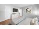 Staged main bedroom with hardwood floors, queen bed, and TV at 8416 Buckingham Dr, Columbus, IN 47201