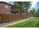 View of a lush backyard, including a fence, grass, and a brick condo building at 8503 Canterbury W Sq # D, Indianapolis, IN 46260