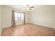 Bright bedroom featuring hardwood floors, a ceiling fan, and a window with neutral-colored curtains at 8503 Canterbury W Sq # D, Indianapolis, IN 46260