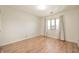Well-lit bedroom with neutral walls, hardwood floors, and a window with curtains at 8503 Canterbury W Sq # D, Indianapolis, IN 46260