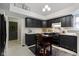 Well-lit kitchen with an island cart, dark cabinetry, and updated appliances at 8599 Lansdowne Dr, Fishers, IN 46038