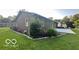 View of the backyard from the side, featuring a stone bordered garden with a patio at 865 Countryside Ln, Columbus, IN 47201