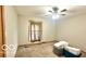 This bedroom features a ceiling fan and a window; needs TLC at 865 Countryside Ln, Columbus, IN 47201