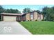 Charming single-story home featuring a spacious front yard, attached garage, and inviting front porch at 865 Countryside Ln, Columbus, IN 47201