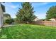 Large fenced backyard features a mature tree and lawn, ideal for outdoor activities and private relaxation at 8908 Sunningdale Blvd, Indianapolis, IN 46234