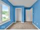 Comfortable bedroom with bright blue walls, a large window, and access to closet space at 8908 Sunningdale Blvd, Indianapolis, IN 46234