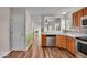 Kitchen featuring stainless steel appliances, wood cabinetry, tile backsplash and wood-look flooring at 8908 Sunningdale Blvd, Indianapolis, IN 46234