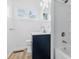 Bathroom features a vanity with blue cabinet, white tiled walls, and shower/tub combo at 903 Sunset Dr, Lebanon, IN 46052