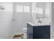 Bathroom features a vanity with blue cabinet, white tiled walls, and toilet at 903 Sunset Dr, Lebanon, IN 46052