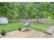Backyard featuring egg chair, flowers, shed, wood fence, and lush green lawn at 923 42Nd St, Indianapolis, IN 46205