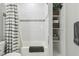 Clean bathroom showcasing a tiled shower with gray accents, shelving with storage baskets, and a decorative gray bath mat at 923 42Nd St, Indianapolis, IN 46205