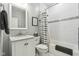 Well-lit bathroom featuring a vanity with a marble countertop, a framed mirror, and a shower with a gray and white striped curtain at 923 42Nd St, Indianapolis, IN 46205