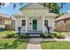 Charming home featuring a covered front porch with vibrant plants and a freshly painted teal front door at 923 42Nd St, Indianapolis, IN 46205