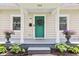 Charming exterior featuring a welcoming porch with colorful planters and a vibrant green door at 923 42Nd St, Indianapolis, IN 46205