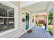 A close up shot of the inviting front porch, the vibrant green front door, and potted plants at 923 42Nd St, Indianapolis, IN 46205