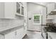 Bright kitchen features white cabinets, stainless steel appliances, light countertops, and stylish tile flooring at 923 42Nd St, Indianapolis, IN 46205