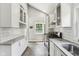 Bright kitchen features white cabinets, stainless steel appliances, light countertops, and stylish tile flooring at 923 42Nd St, Indianapolis, IN 46205