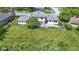 Aerial view of the home displaying the large backyard, concrete patio, landscaping, and shingled roof at 10502 E Lakeshore Dr, Carmel, IN 46033