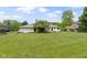 View of a large backyard with mature trees, landscaping, and the rear of a two-story home at 10502 E Lakeshore Dr, Carmel, IN 46033
