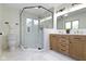 Modern bathroom featuring a glass-enclosed shower, wooden vanity, and updated fixtures at 10502 E Lakeshore Dr, Carmel, IN 46033