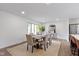 Bright dining room featuring a wooden table set for six, neutral colors, and natural light from the large window at 10502 E Lakeshore Dr, Carmel, IN 46033