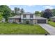 Charming two-story home featuring stone accents, gray shingles, a well-manicured lawn, and attached garage at 10502 E Lakeshore Dr, Carmel, IN 46033