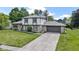 Two-story home with stone facade, gray shingles, an attached garage, and a concrete driveway at 10502 E Lakeshore Dr, Carmel, IN 46033