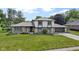 Charming two-story home featuring stone accents, gray shingles, a well-manicured lawn, and attached garage at 10502 E Lakeshore Dr, Carmel, IN 46033