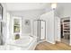 Bright bathroom featuring a soaking tub, glass shower, and walk-in closet with custom shelving at 10965 Fairway Ridge Ln, Fishers, IN 46037