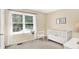 A cozy Bedroom with a white crib, a large window, and neutral-toned decor at 10965 Fairway Ridge Ln, Fishers, IN 46037
