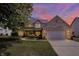 Charming two-story home with brick accents, attached garage, and a well-manicured lawn under a beautiful sunset sky at 10965 Fairway Ridge Ln, Fishers, IN 46037