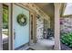 Inviting front porch with a light blue front door and seating area, adorned with a wreath and colorful flowers at 10965 Fairway Ridge Ln, Fishers, IN 46037