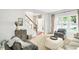 Cozy living room with carpeted floors, a staircase view, and comfortable seating arrangement filled with natural light at 10965 Fairway Ridge Ln, Fishers, IN 46037