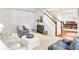 Comfortable living room with neutral carpet, elegant furnishings, and a staircase view leading to the dining area at 10965 Fairway Ridge Ln, Fishers, IN 46037