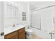 Bright bathroom featuring a wood vanity, framed mirror, and tub-shower combination with sliding glass door at 1108 Northfield Ln, Anderson, IN 46011