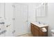 Bright bathroom featuring a wood vanity, framed mirror, and white door at 1108 Northfield Ln, Anderson, IN 46011
