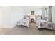 This carpeted bedroom has twin beds, natural light, and neutral decor with an adjacent door at 1108 Northfield Ln, Anderson, IN 46011