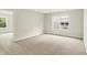 Bright bedroom with neutral carpet, large window, and an open doorway to an adjacent room at 11437 High Grass Dr, Indianapolis, IN 46235