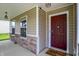 Close-up of the front entrance with a stylish maroon door, stone accents, and a welcoming welcome mat at 11437 High Grass Dr, Indianapolis, IN 46235