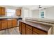 Kitchen island with dark countertop, wood cabinets, and view to the kitchen with stainless appliances at 11437 High Grass Dr, Indianapolis, IN 46235