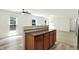 Kitchen island with dark countertop and oak cabinets, view to the living room and backyard at 11437 High Grass Dr, Indianapolis, IN 46235
