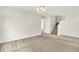 Bare living room with neutral carpet and white walls that shows the stairs to the upper level at 11437 High Grass Dr, Indianapolis, IN 46235