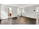 Hardwood living room featuring modern lighting and open access to other rooms, enhancing flow at 11437 High Grass Dr, Indianapolis, IN 46235